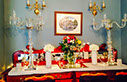 Credenza colourfully decorated with flowers and candle holders for event.